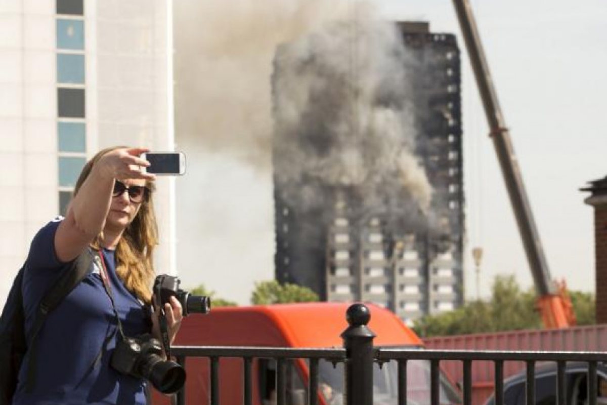 Туристи си правят селфита с Grenfell Tower 