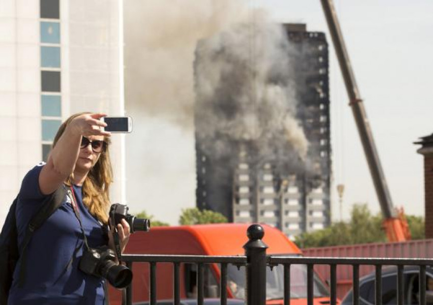 Туристи си правят селфита с Grenfell Tower 